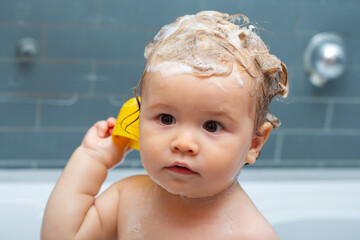 Smiling beautiful baby bathing in shower. Happy funny baby bathed in the bath.