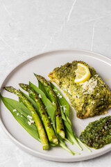 Salmon fillet with green wild garlic pesto. Green asparagus with salmon