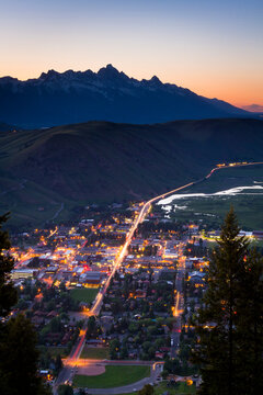 Lights of Jackson, Wyoming come on as the day fades behind the Teton Mountains, as seen from Snow King.
