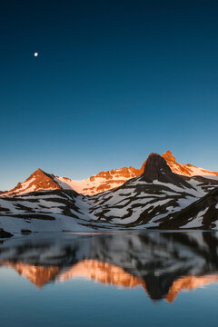 Ice lake Basin, CO: The moon hangs in the sky as the morning Alpenglow reflects off of Ice Lake