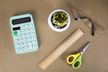 on a desktop with a calculator, paper and glasses. d