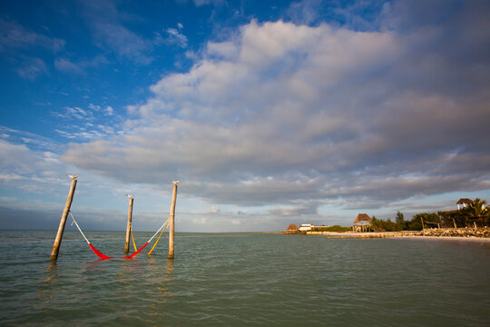 Red and yellow hammocks in the waters of the Gulf of Mexico on Holbox Island, Mexico.