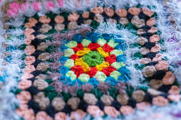 Knitted colored rug made of woolen threads.