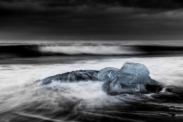 Detailed image of iceberg on the black sand beach, under a dramatic sky at Jokulsarlon, Iceland.