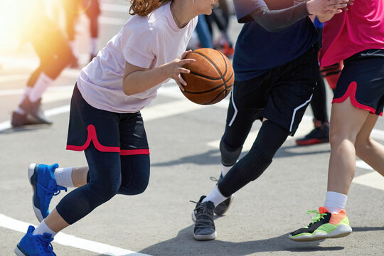 Girls in sportswear play street basketball