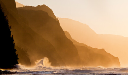 A wave crashes along the rocky shores of Ke'e Beach on Kauai's Na Pali Coastline.