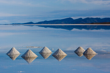 Piles of salt made by salt miners, dry during the rainy season in the Salar de Uyuni, Potosi, Bolivia