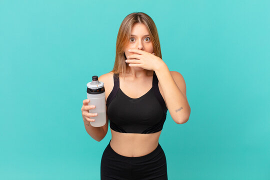 young pretty fitness woman covering mouth with hands with a shocked