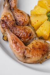 Modern restaurant dish of roasted quail legs decorated with pineapple slices. pesto and asparagus