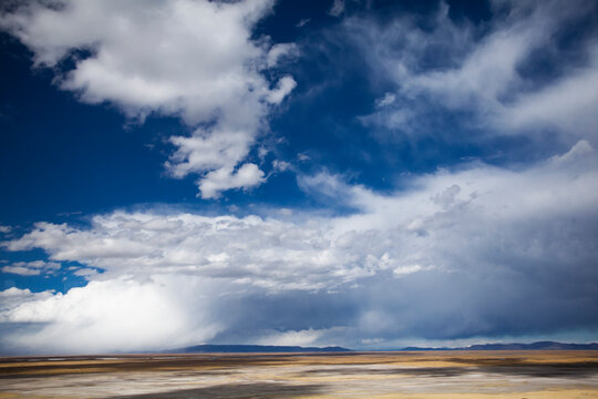 On a bus to Puno, Peru near Lake Titicaca, storm clouds and a yellowish plain.