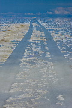 Vehicle tracks leave their mark in the softened salt bed of the Salar de Uyni in the rainy season in the Department of Potosi in Bolivia.