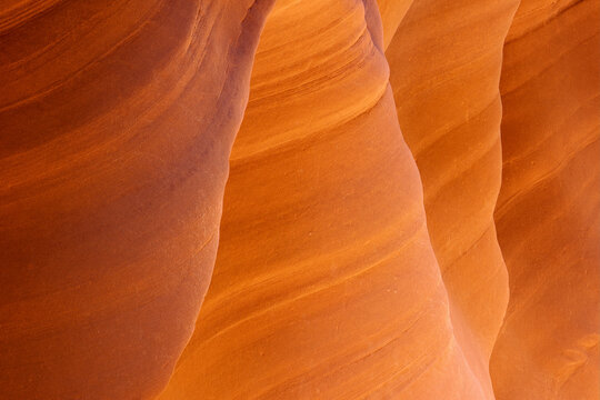 An abstract view of the sandstone edges and lines accentuated by reflected light in a remote slot canyon of the Arizona desert.