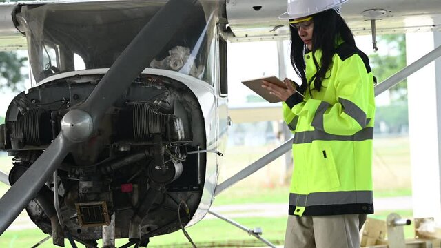 Technician fixing the engine of the airplane,Female aerospace engineering checking aircraft engines,Asian mechanic maintenance inspects plane engine