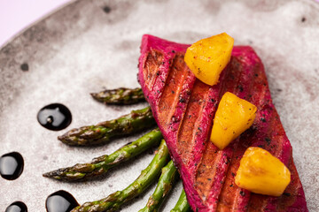 Beetroot marinated salmon with asparagus and pineapple.