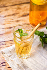 The glass of citrus iced tea on a marble tray and wooden table.