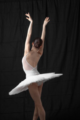 Young beautiful skinny ballerina is posing in studio