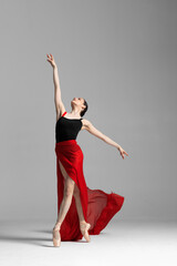 Young beautiful skinny ballerina is posing in studio