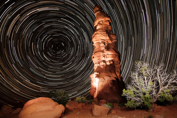 Star trails and Standing Rock illuminated by photo lights, in The Maze region of Canyonlands, Utah.