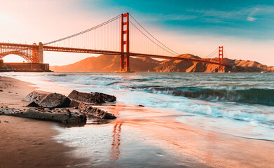 Long exposure of a stunning sunset at the beach by the famous Golden Gate Bridge in San Francisco, California - obrazy, fototapety, plakaty