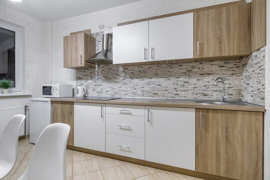 Interior of the modern luxure kitchen  in studio apartments in minimalistic style with light white color