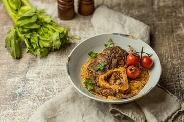 Osso buco traditional italian meat dish served with herbs and tomatoes