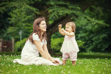 Mother and little daughter playing in the park