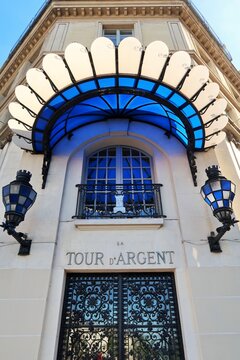 Gastronomie française, façade et enseigne du célèbre restaurant gastronomique La Tour d'Argent à Paris, avec une porte en fer forgé et une marquise en verre bleu – avril 2021 (France)