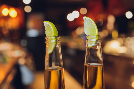 Close up image of multiple beer bottles with limes inserted.