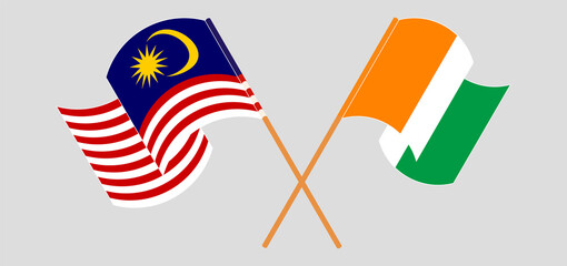 Crossed and waving flags of Malaysia and Republic of Ivory Coast