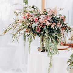 Wedding arrangement of natural flowers in boho style on wedding table. 