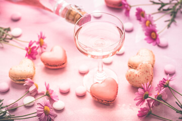 Obraz na płótnie Canvas Happy Mothers Day - sweet macarons in heart shape and glass of rose sparkling wine
