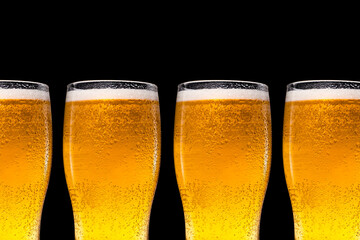 A row of beer glasses with beer on a black background.