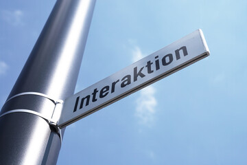 Interaktion Schild vor blauen Himmel