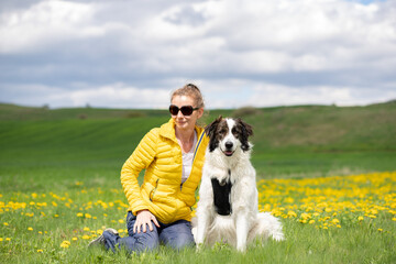 woman with dog relaxing in green spring landscape