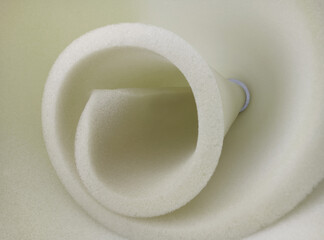 rolls of white sponge foam material in a spiral or cone shape with a soft texture