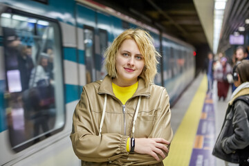 Subway station in Istanbul, Turkey, young Caucasian woman stands on platform while waiting for...