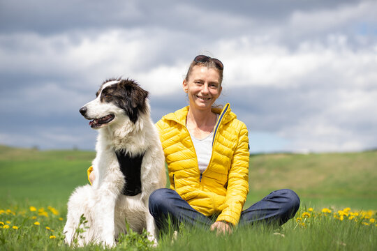 woman with dog relaxing in green spring landscape