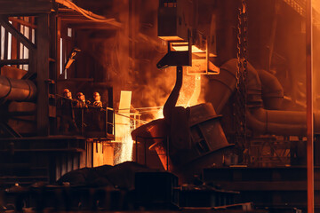 Molten iron pouring from ladle container into mold, workers control process, steel foundry factory,...