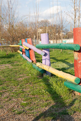 Rustic hedge made of logs of different vibrant colors.