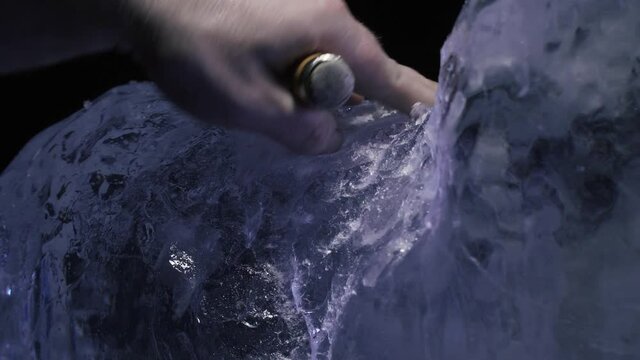 Using chisel and hammer to create details on an ice sculpture, artist, 4k
