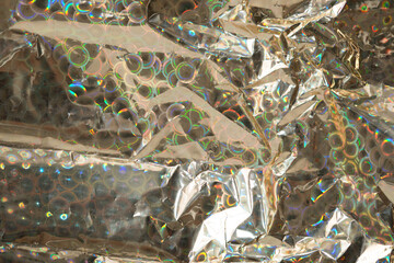 gold metallic wrapping paper with iridescent or spectral shine (circles) with folds and creases