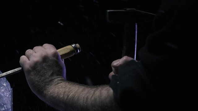 Ice flakes flying around while an artist is using a hammer and chisel, 4k