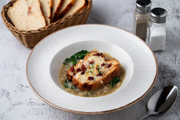 French onion soup with spinach and roasted soft brioche and melted cheese, light, minimalist shot