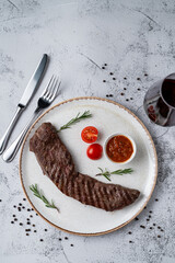 Top view of tender sirloin with chili sauce on black dish, directly above view