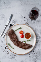 Top view of tender sirloin with chili sauce on black dish, directly above view