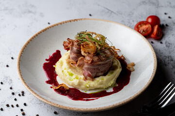 Pork medallion with crispy bacon with mashed potato, close appetizing shot