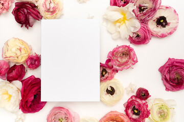 Beautiful floral flat lay with blank stationery card and fresh ranunculus flowers