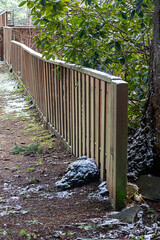 A wooden fence covered in light dusting of snow