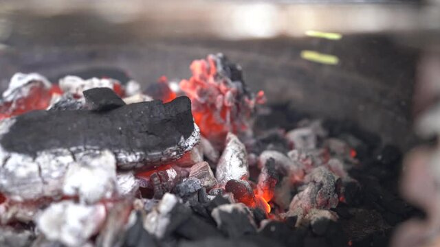 Ascuas y carbon encendidos ardiendo en barbacoa metalica