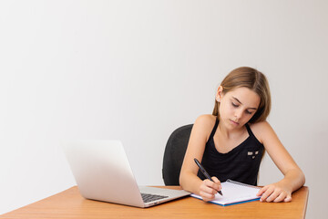 Jovem estudando remotamente com notebook, papel e caneta